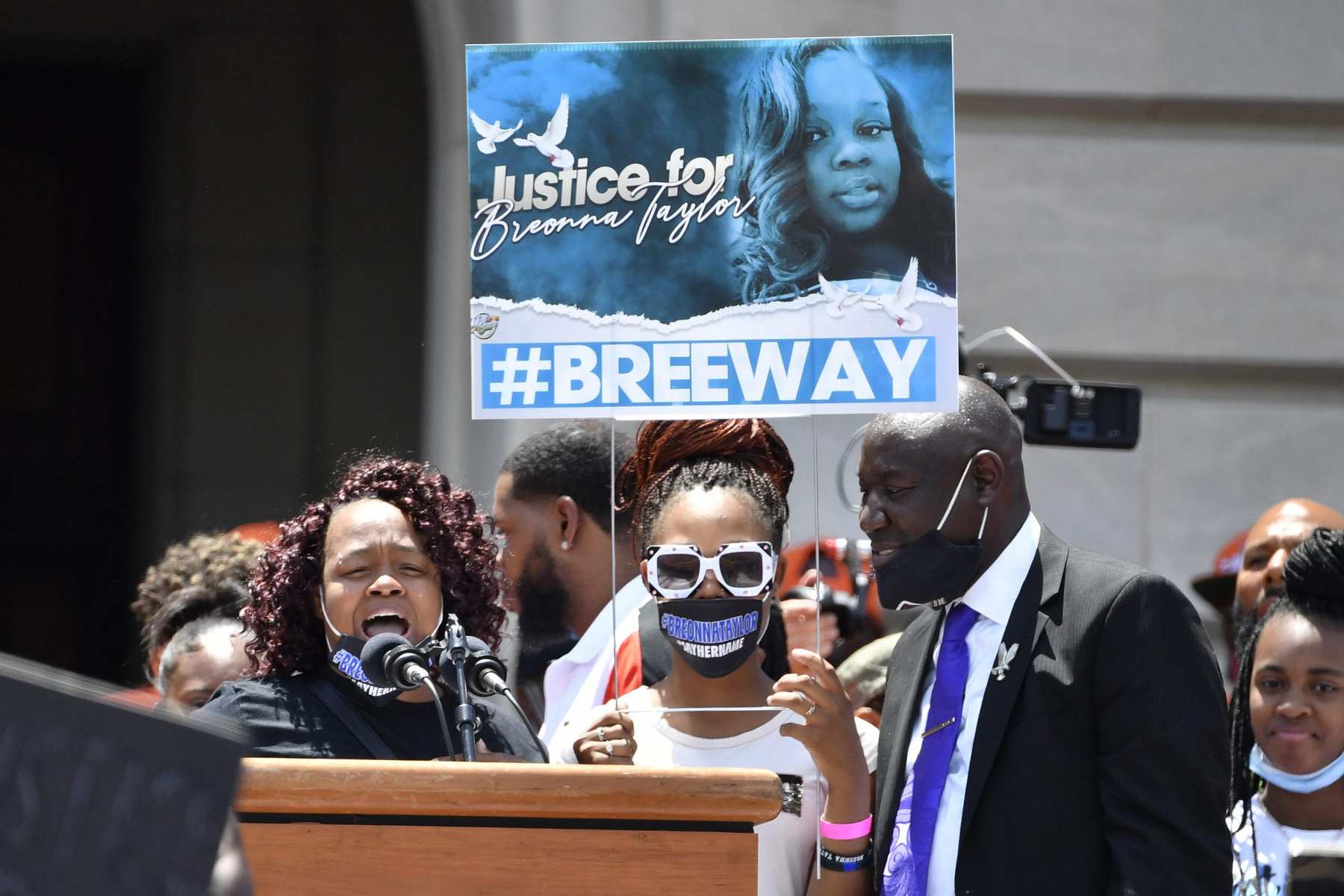 A group of people stand at a podium with a poster.