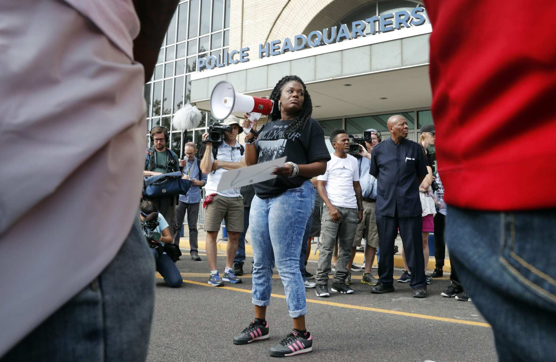 Woman with a bullhorn speaks to a crowd.