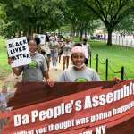 A group of children and parents from the Bronx, holding a banner that reads Da People's Assemblage, attending the 2020 March on Washington to protest.