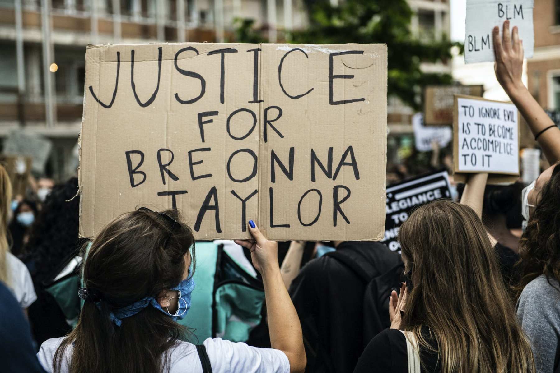 A girl holding a cardboard sign asking justice for Breonna Taylor demonstrating in Mestre, Venice, Italy on June 6, 2020, to protest the killing of George Floyd by a policeman in the USA.