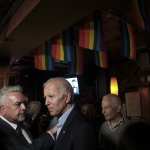 Joe Biden at the Stonewall Inn standing under LGBTQ flags.