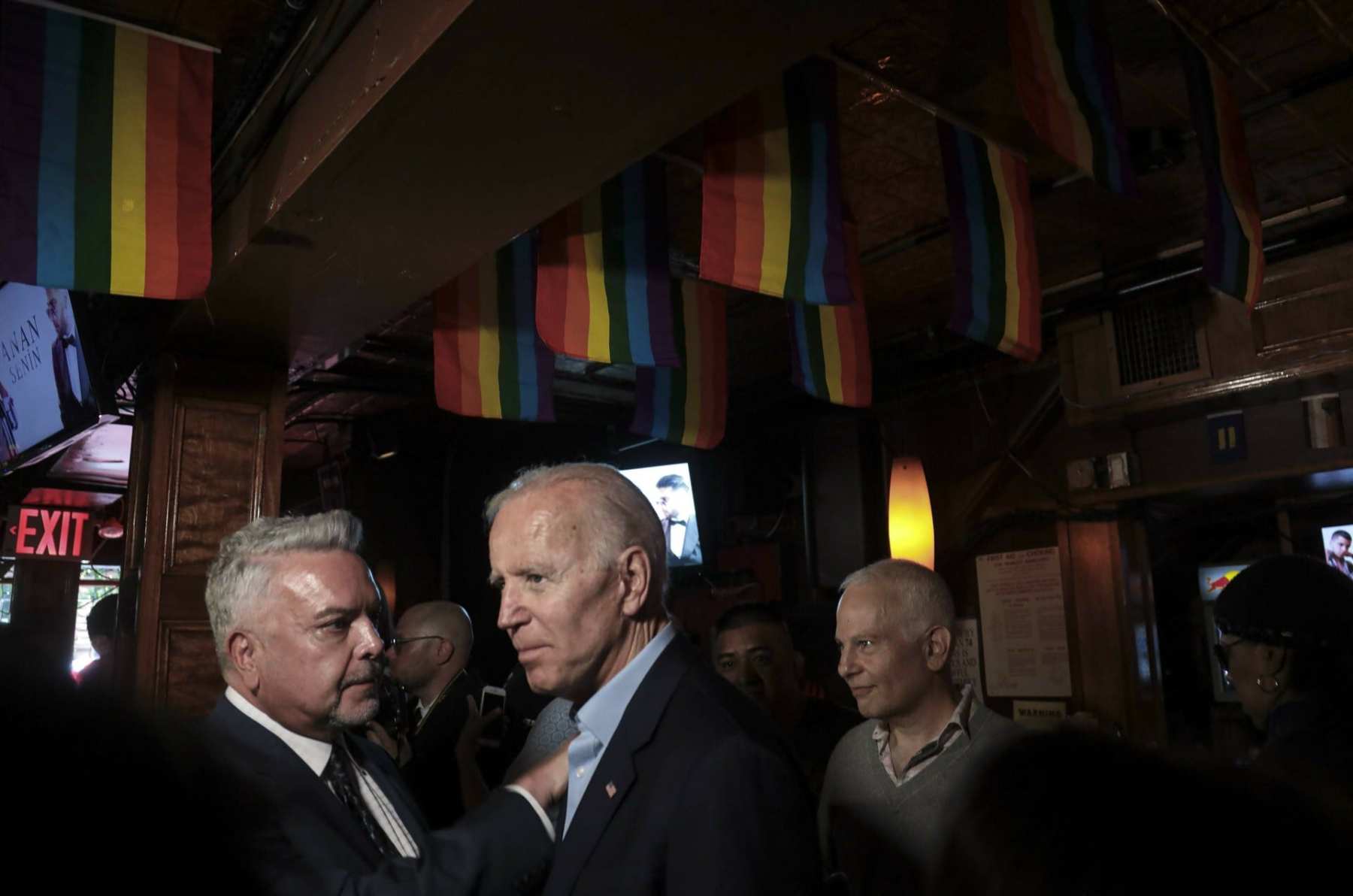 Joe Biden at the Stonewall Inn standing under LGBTQ flags.