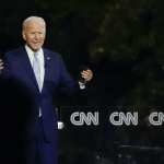 Joe Biden speaks to a crowd from a stage at a town hall event.