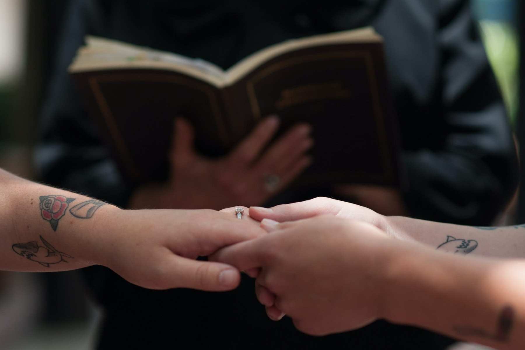 Two people holding hands at their ewdding.