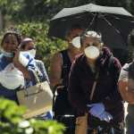 Women wearing protective masks wait in a queue to receive food assistance provided by the Second Harvest Food Bank of Central Florida at a food distribution event staffed by volunteers at the Calvario City Church. Food banks across the United States are being overwhelmed due to the thousands of people who have lost their jobs due to the coronavirus (COVID-19) pandemic.