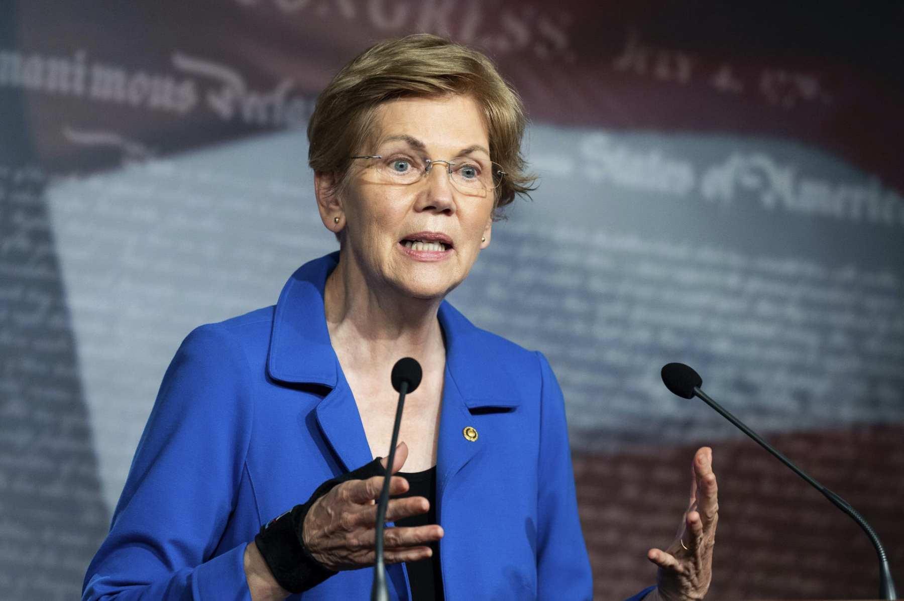 Elizabeth Warren speaks at a podium.