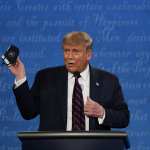 In this Sept. 29, 2020, file photo, President Donald Trump holds up his facemask during the first presidential debate at Case Western University and Cleveland Clinic, in Cleveland, Ohio. President Trump and first lady Melania Trump have tested positive for the coronavirus, the president tweeted early Friday. In this (AP Photo/Julio Cortez, File)