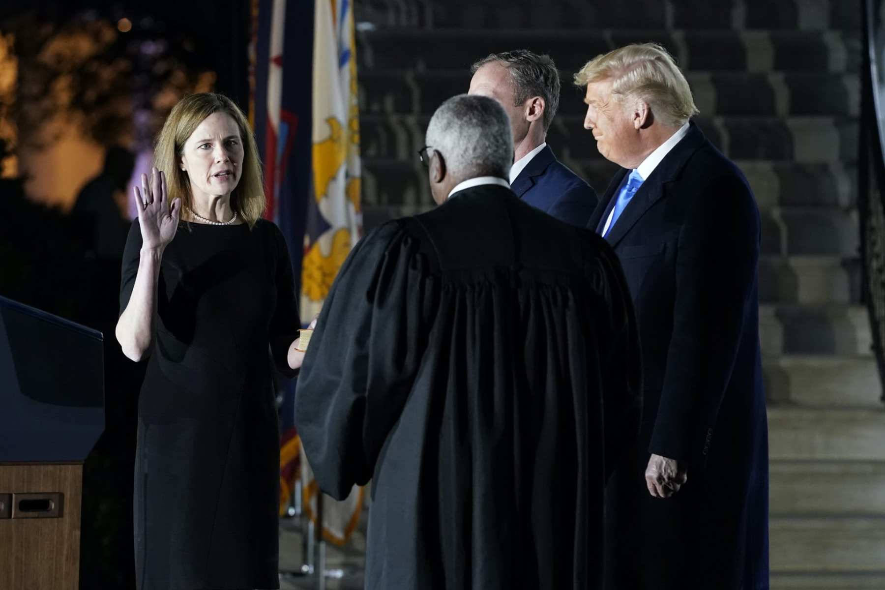 President Donald Trump watches as Supreme Court Justice Clarence Thomas administers the Constitutional Oath to Amy Coney Barrett on the South Lawn of the White House in Washington, Monday, Oct. 26, 2020, after Barrett was confirmed by the Senate earlier in the evening.