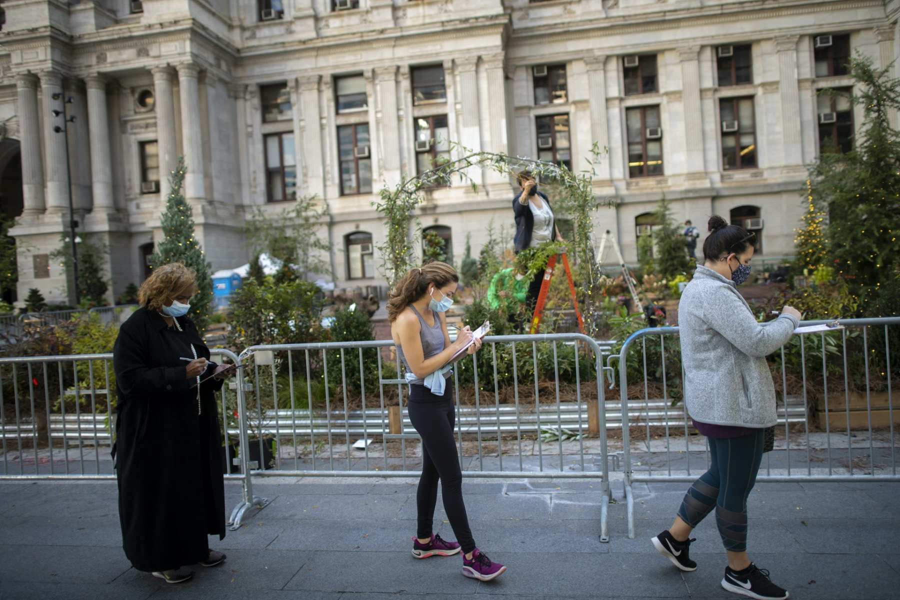 Voters in Philadelphia complete registration paperwork while waiting outside of Philadelphia City Hall for early voting on October 27, 2020.