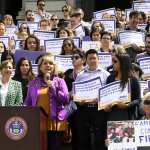 Protesters gather at a rally in Denver for paid family leave.