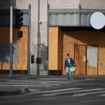 A woman wearing a facemask to prevent the spread of coronavirus walks past a boarded up storefront at the intersection of Hill Street and 5th Street in downtown Los Angeles, California, November 5, 2020 as the country awaits the result of the November 3 US presidential election. - Businesses in major US cities were boarded up in anticipation of unrest. The nail-biting US election was on the cusp of finally producing a winner Thursday, with Democrat Joe Biden declaring 