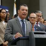 Alex Padilla stands at a podium and speaks into a microphone.