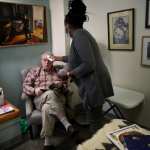 A resident of an assisted living facilty gets his temperature checked.