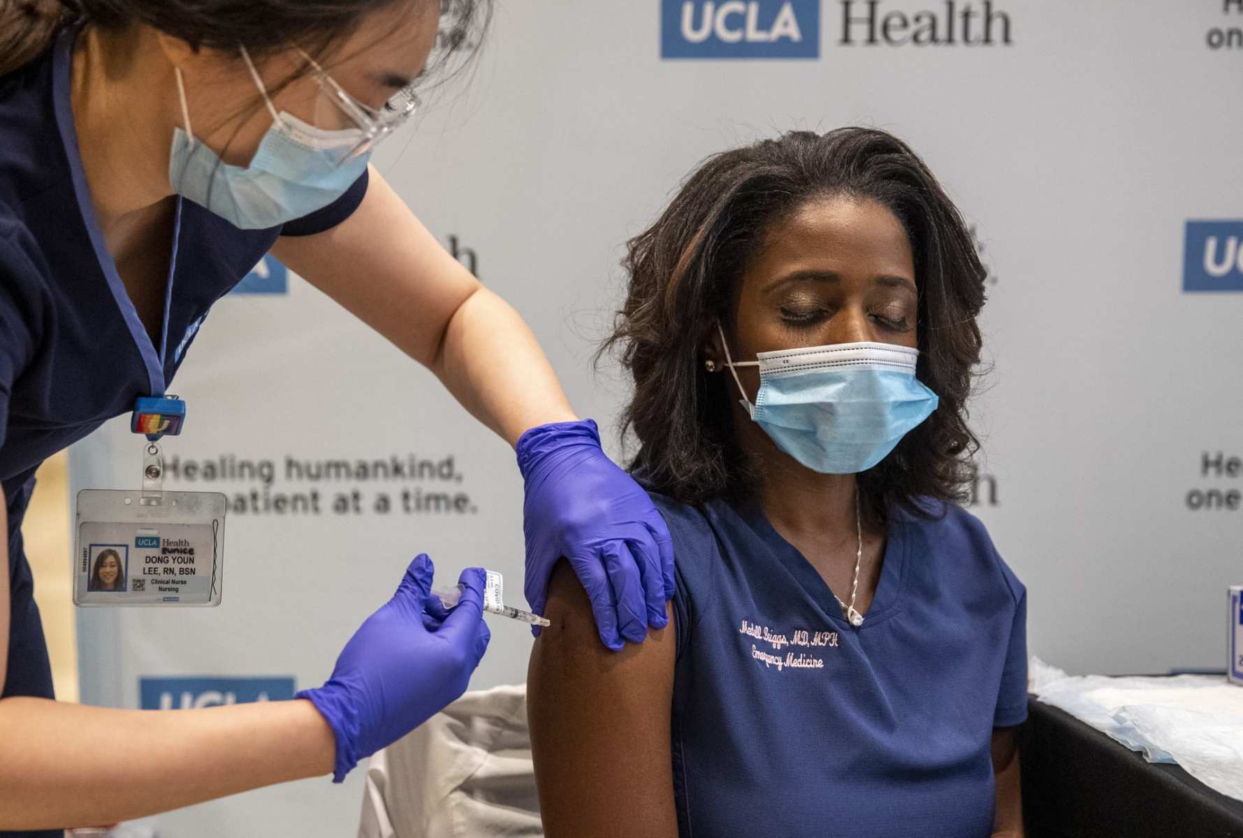 An ER doctor closes her eyes as she receives the COVID-19 vaccine.