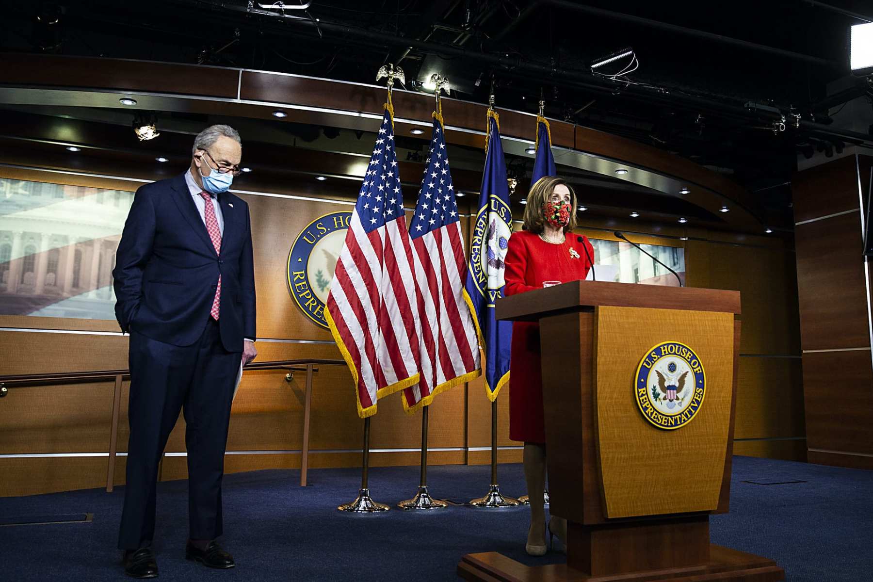 Nancy Pelosi stands at a podium with Chuck Schumer to her right.