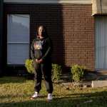 Shanta Scott, 41, stands in the courtyard of her New Orleans apartment complex in a sweatshirt memorializing her late son Jacé.