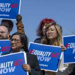 Protesters stand in support of a introduction of the Equality Act.