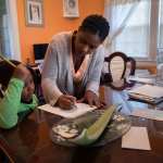 A mother helps her son with his school work at home.