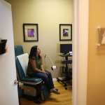 Natalia Reyes sits in the exam room as she gets a health care checkup.