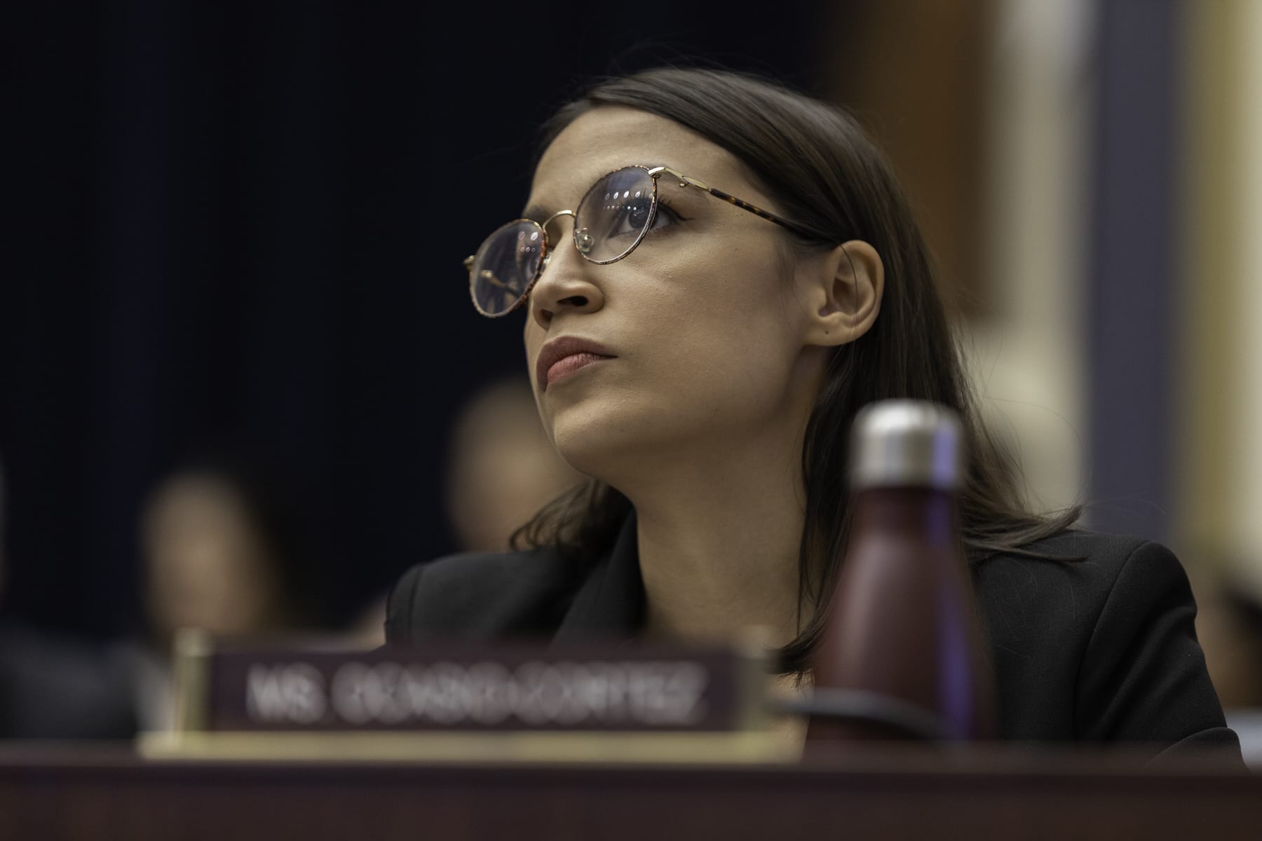 Rep. Alexandria Ocasio-Cortez sitting at a hearing.