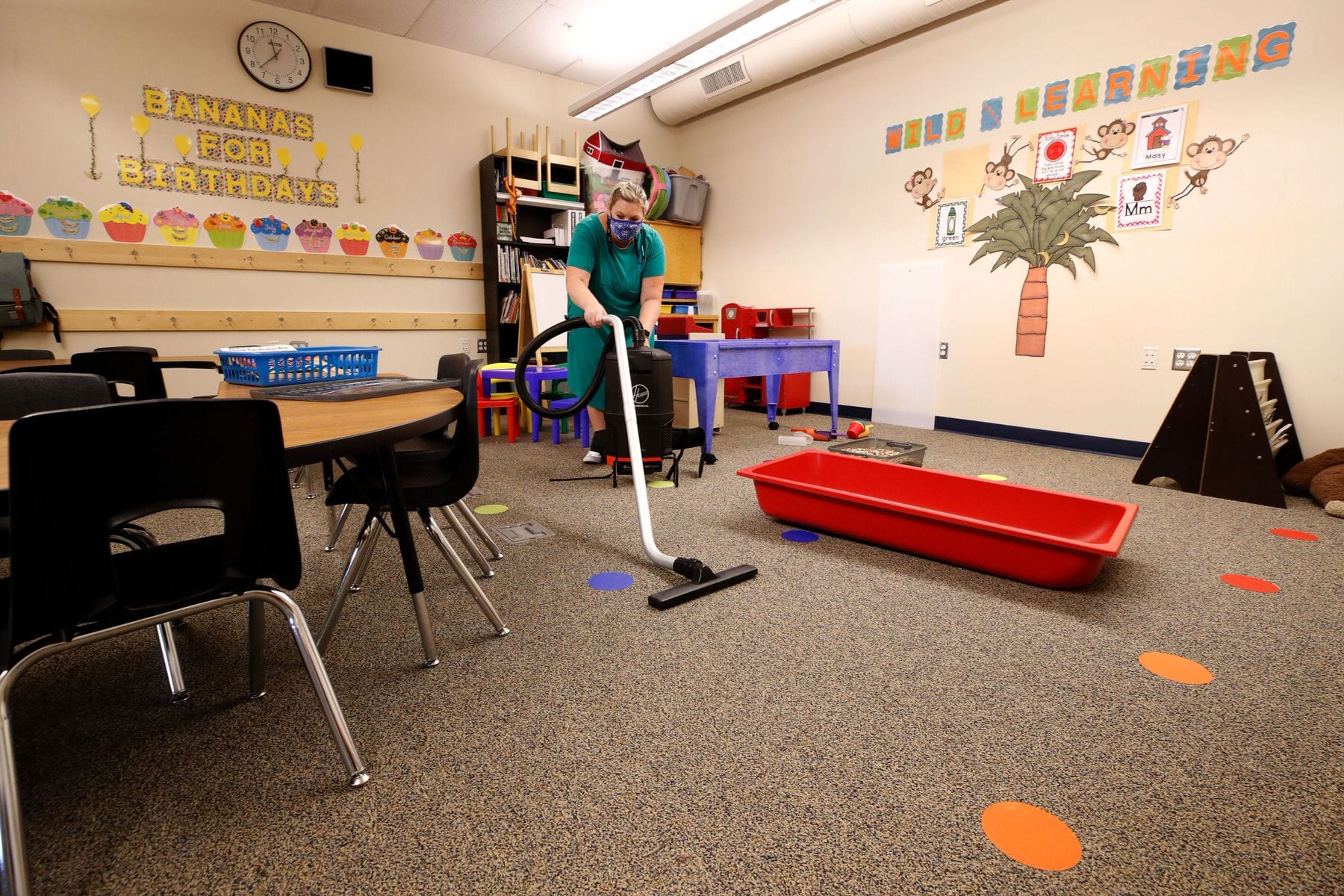 A teacher cleans her classroom.