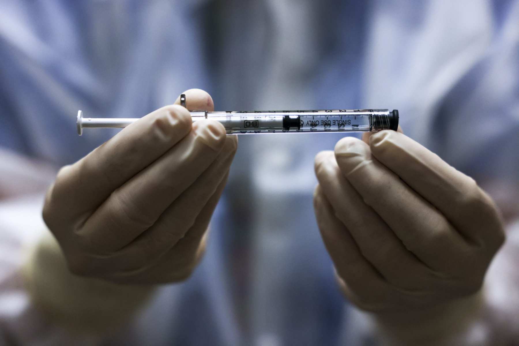 A medical professional holding a dose of a vaccine.