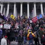 A mob gathers on the steps of the Capitol on January 6.