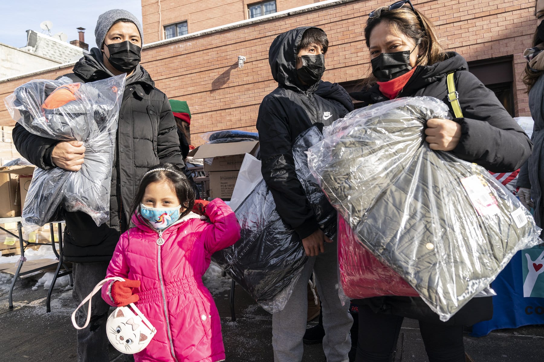 New York Cares volunteers work with a local non-profit organization to distribute toys and winter coats in Corona, Queens.