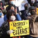 A woman holds a sign that reads 