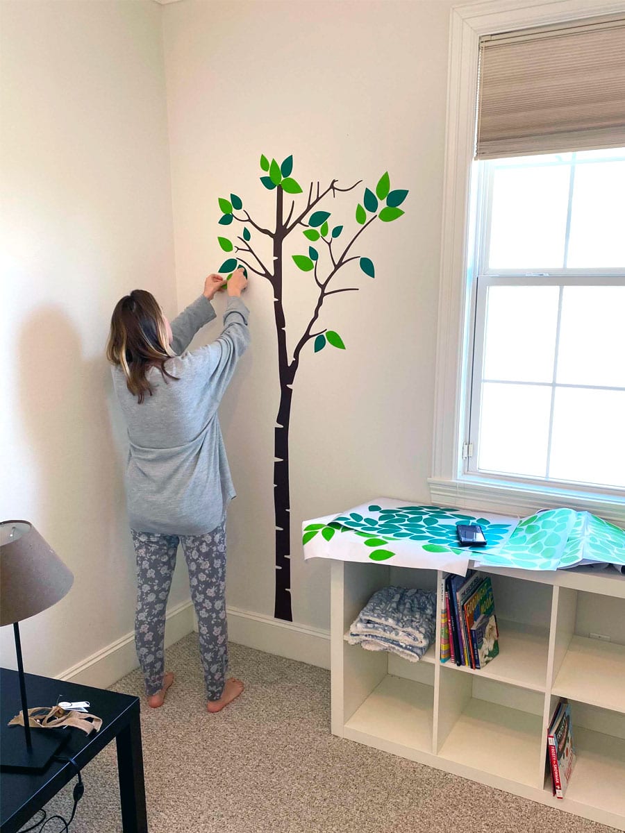 Houston council member Abbie Kamin putting up a wall mural in a nursery.