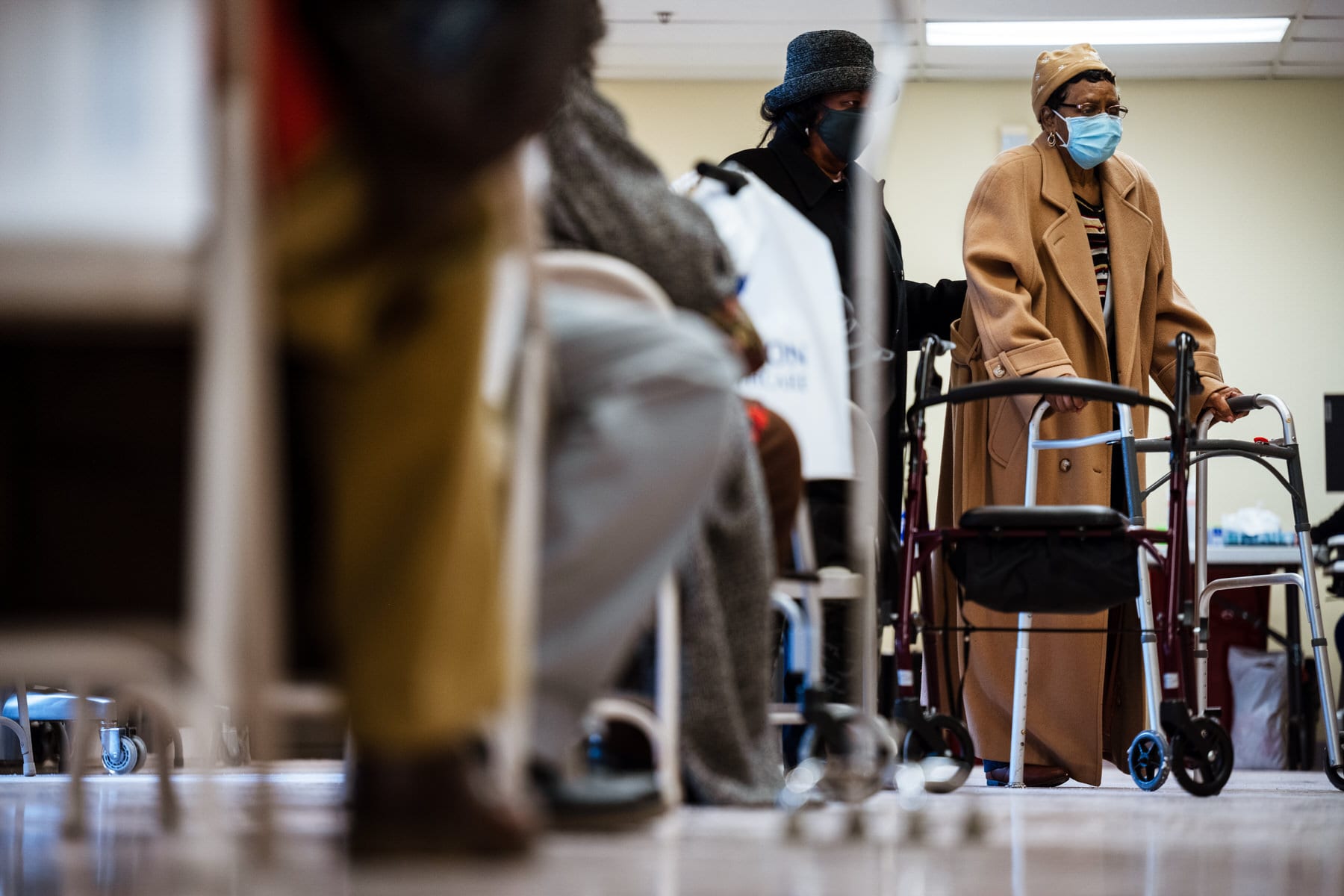 A woman who has just received her Moderna COVID-19 vaccine is escorted by her daughter into the post-injection observation area.