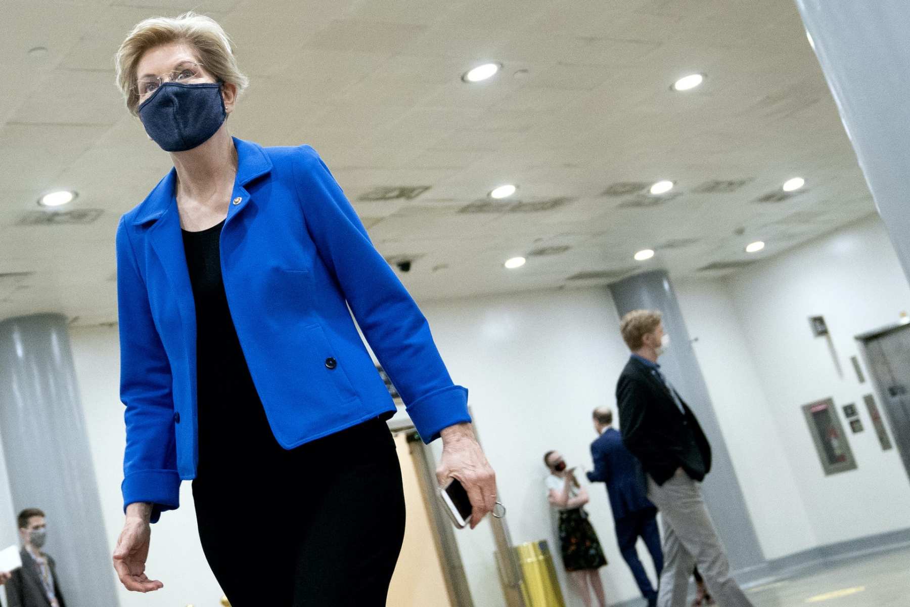 Elizabeth Warren walking while wearing a mask.