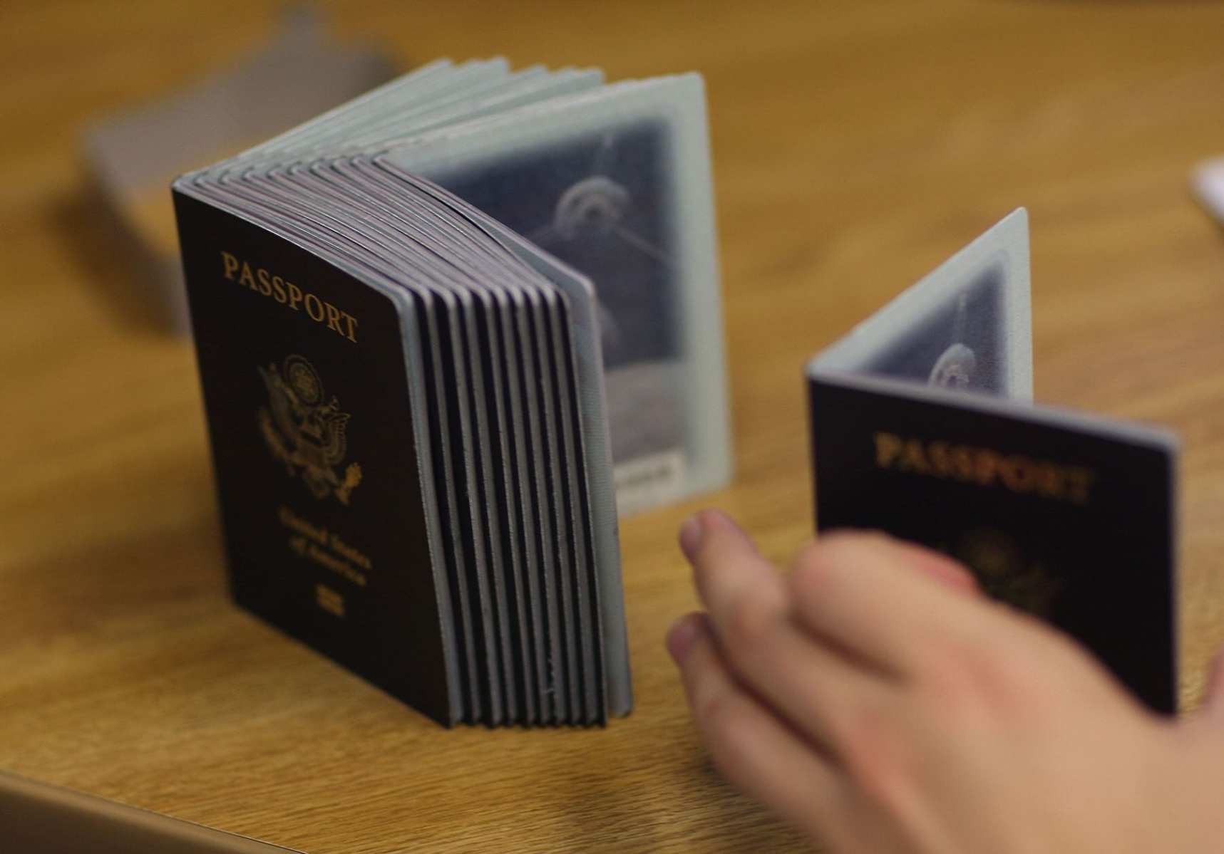 MIAMI - JUNE 22: A Passport Processing employee uses a stack of blank passports to print a new one at the Miami Passport Agency June 22, 2007 in Miami, Florida. The Bush administration postponed for at least six months a requirement that Americans who return to the United States by land or sea from Canada, Mexico and the Caribbean must carry passports. The rule, due to go into effect in January 2008, will be delayed until the summer of that year.