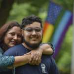 A mom puts her arms around her son.