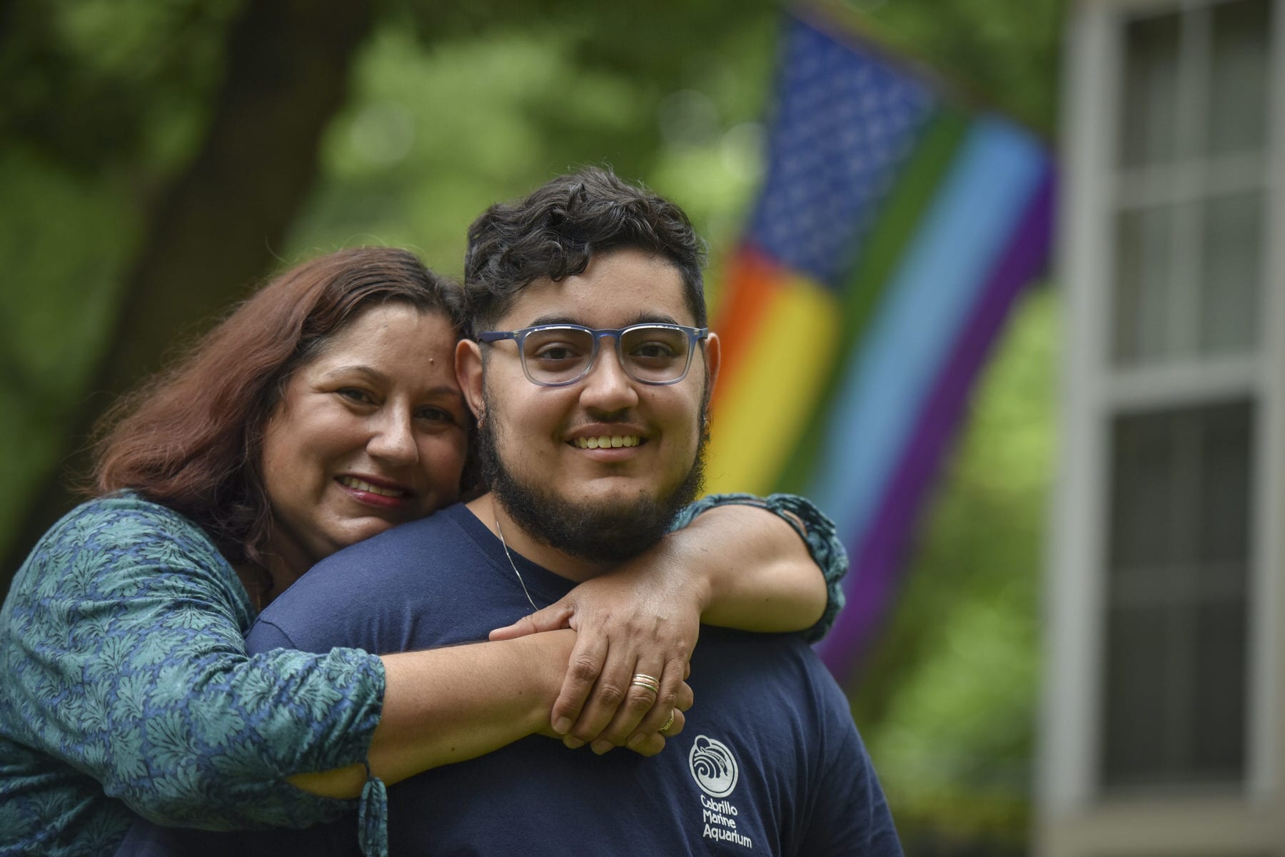 A mom puts her arms around her son.