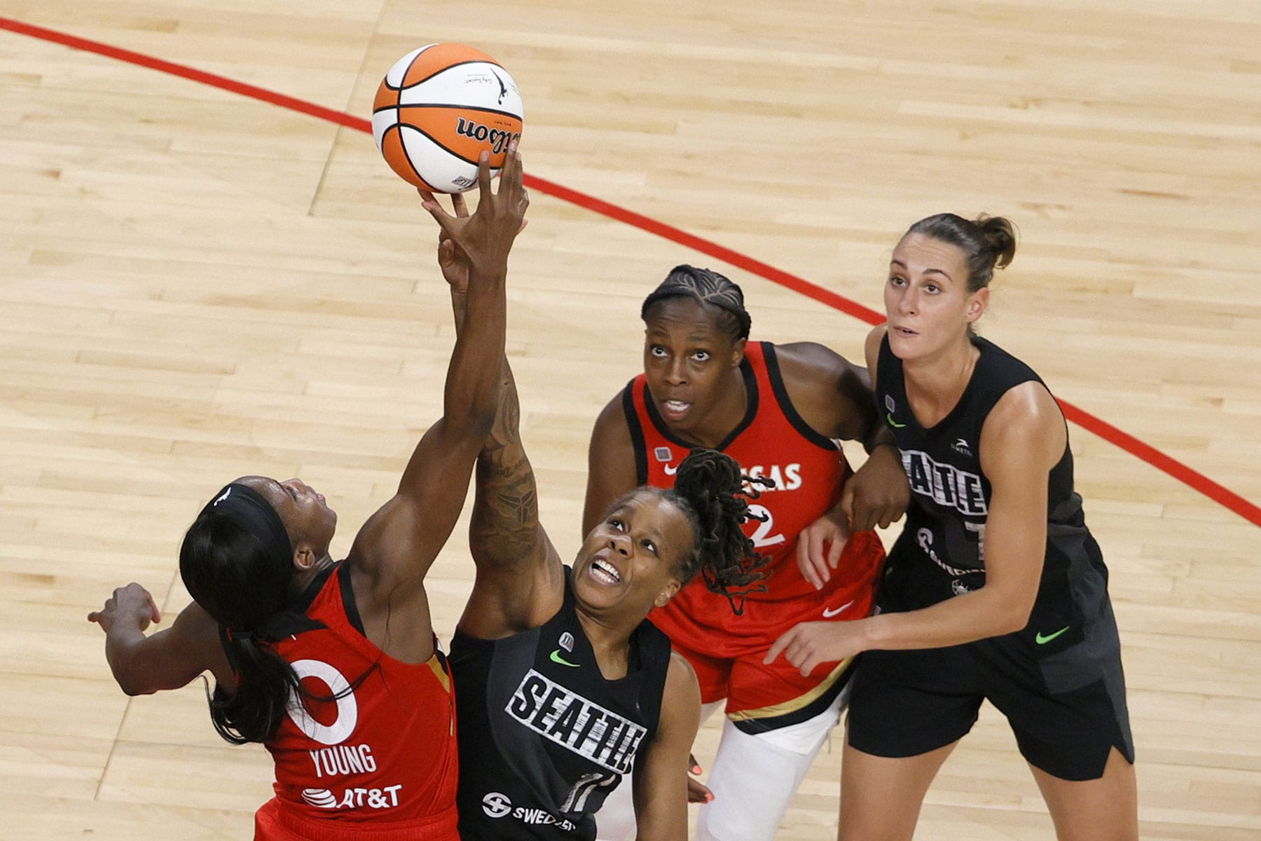 Jackie Young #0 of the Las Vegas Aces and Epiphanny Prince #11 of the Seattle Storm vie for a jump ball as Chelsea Gray #12 of the Aces and Stephanie Talbot #7 of the Storm look on during their game at Michelob ULTRA Arena on June 27, 2021