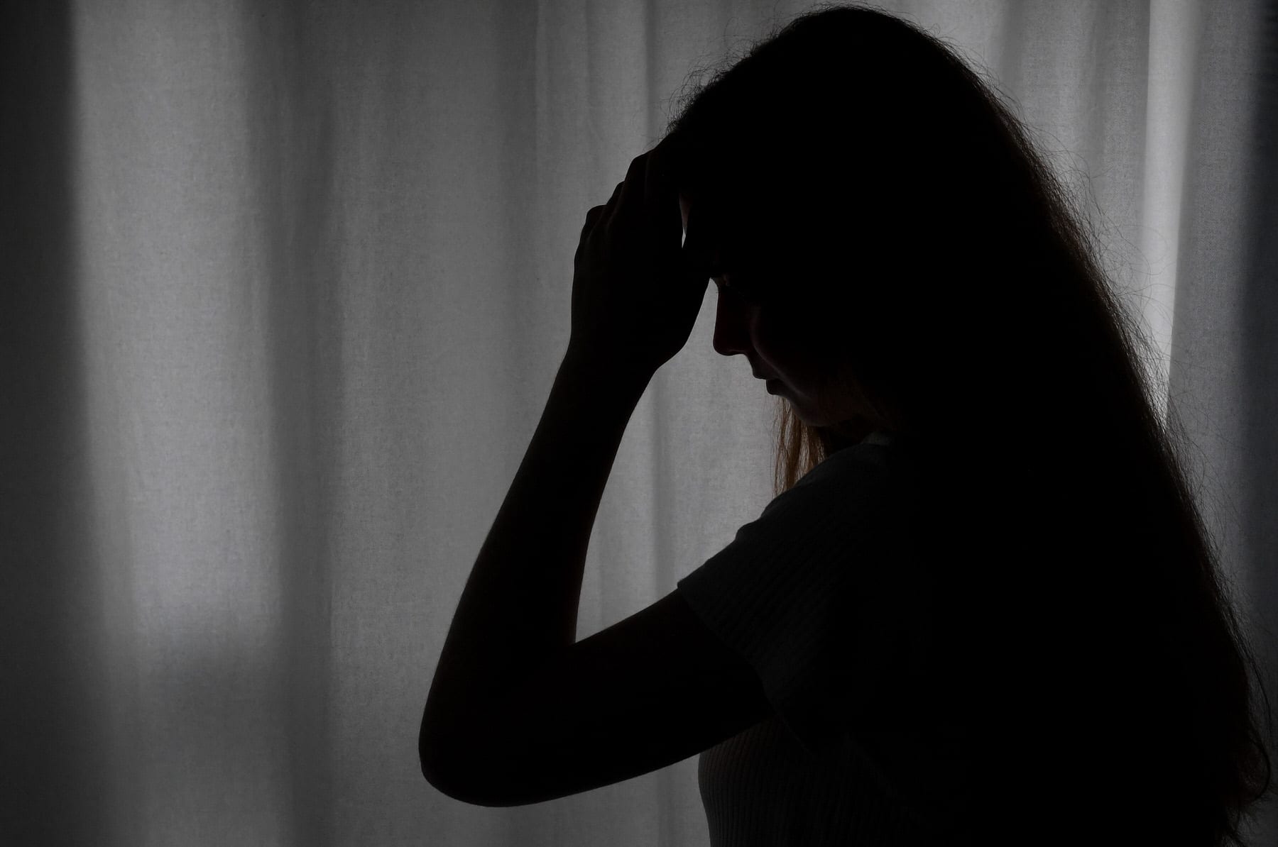 Photo of a depressed teen holding her head.