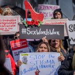 Protesters hold sign about decriminalizing sex work.