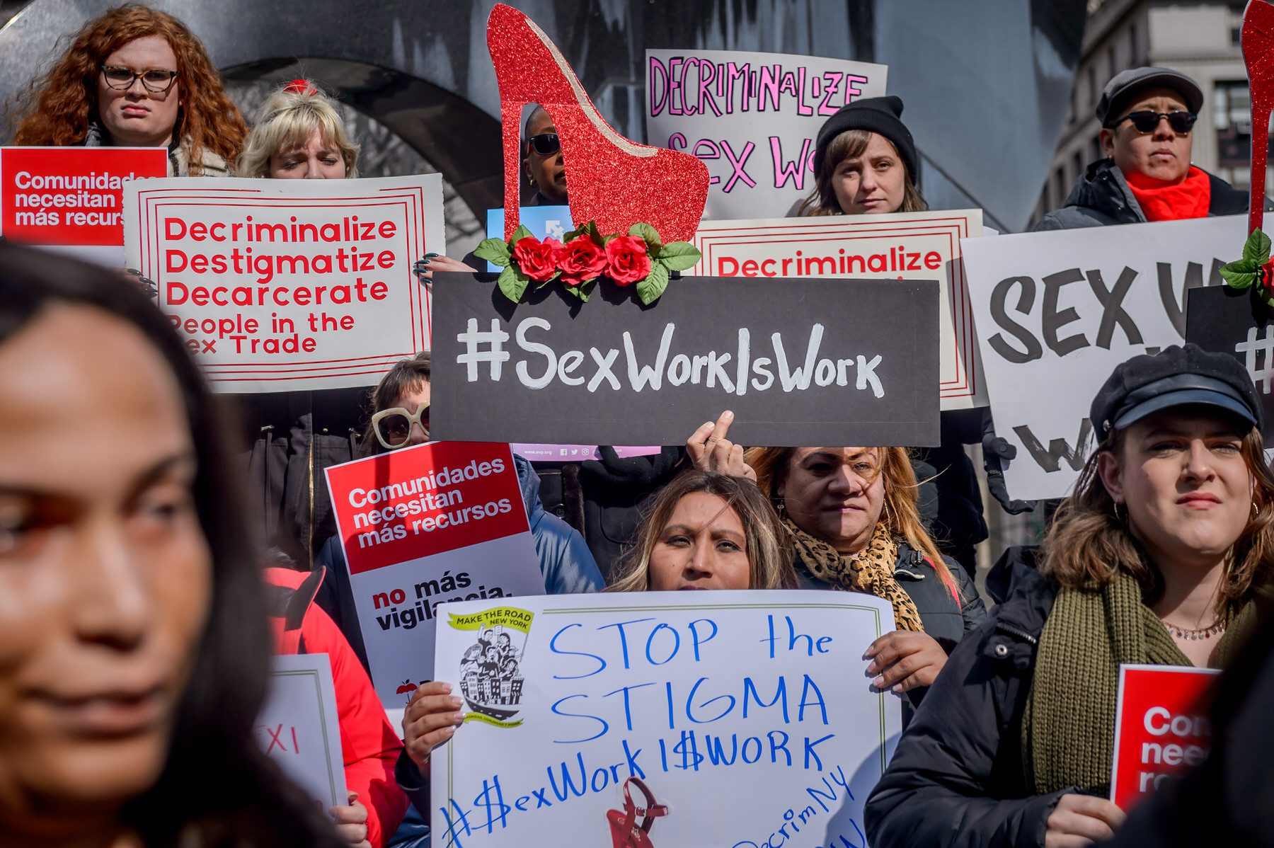 Protesters hold sign about decriminalizing sex work.