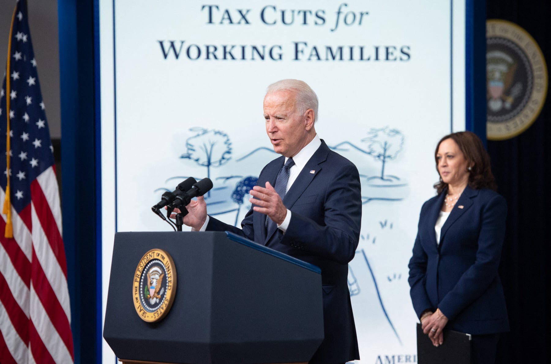 US President Joe Biden, with Vice President Kamala Harris (R), speaks about the Child Tax Credit relief payments.