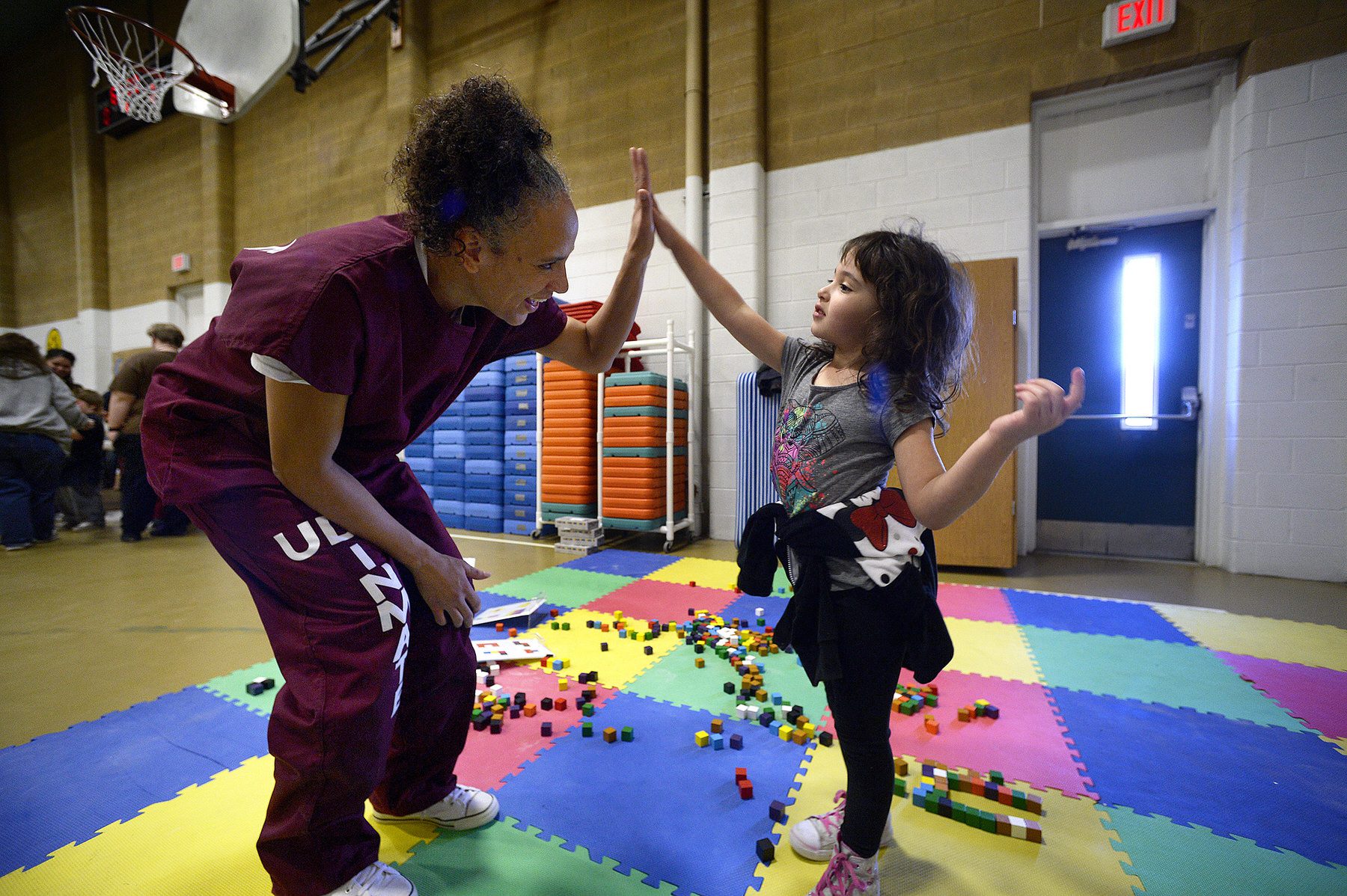 A mother plays with her daughter during a visit in prison.