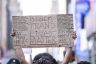 A protester holds a sign that reads, 