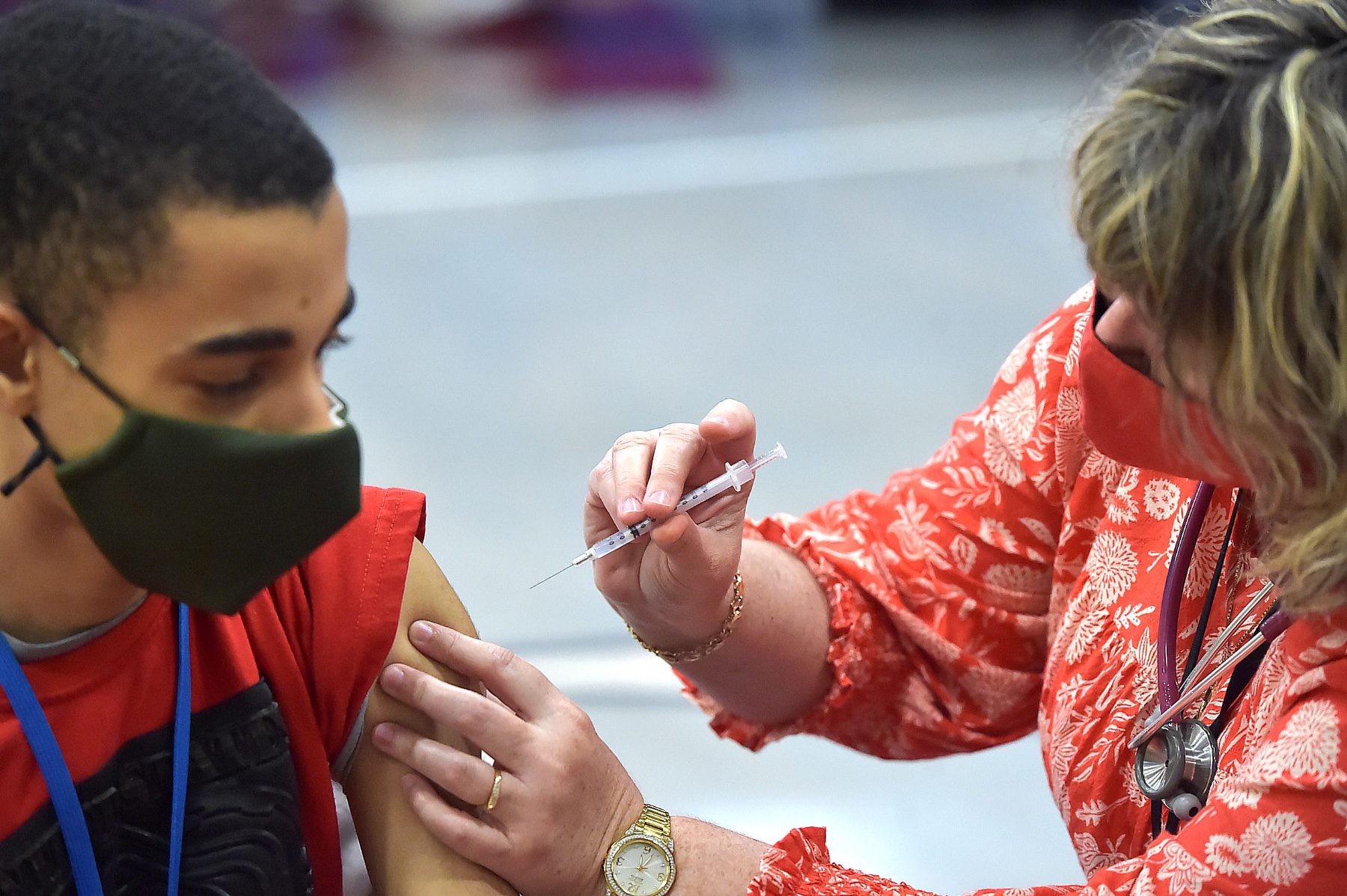 School nurse Kim Davey administers a COVID-19 vaccine.