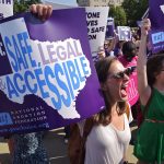 Abortion rights activists hold placards and chant outside of the US Supreme Court.