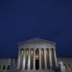 A view of the front of the Supreme Court building at dusk.