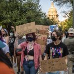 People holding signs that read 