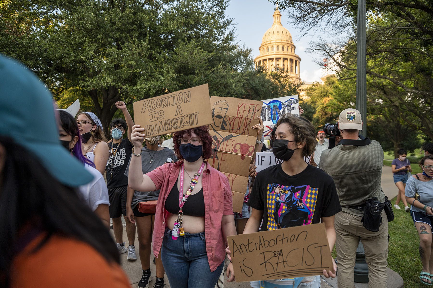 People holding signs that read "Abortion is a human right" and "anti-abortion is racist" march.