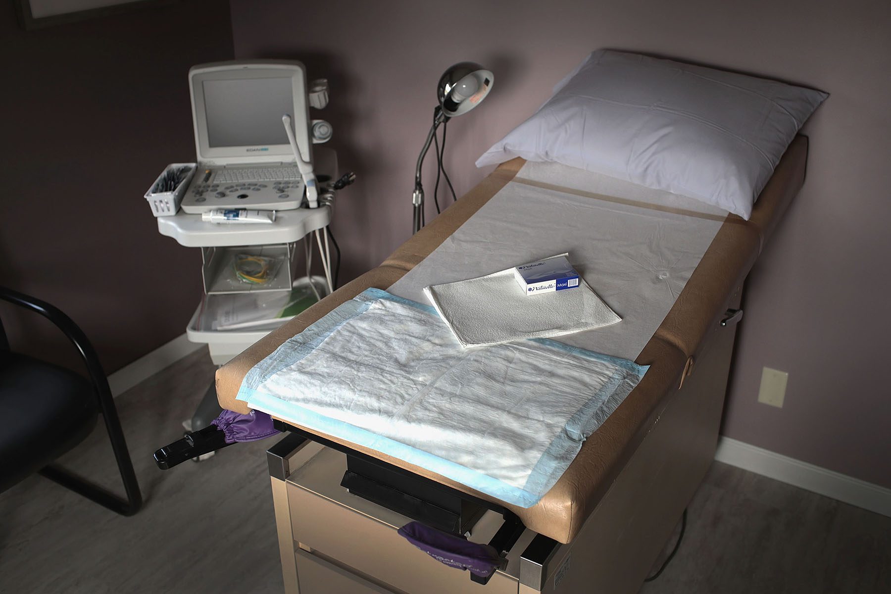 An ultrasound machine sits next to an exam table in an examination room.