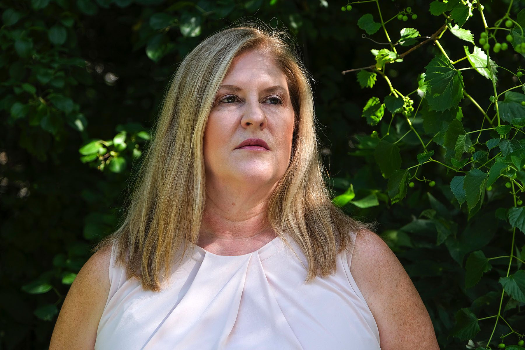 Julie Burkhart poses for a portrait. She looks slightly away from the camera as the sun hits her face.