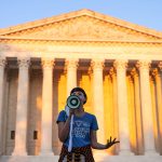 An abortion rights activist speaks outside the Supreme Court.